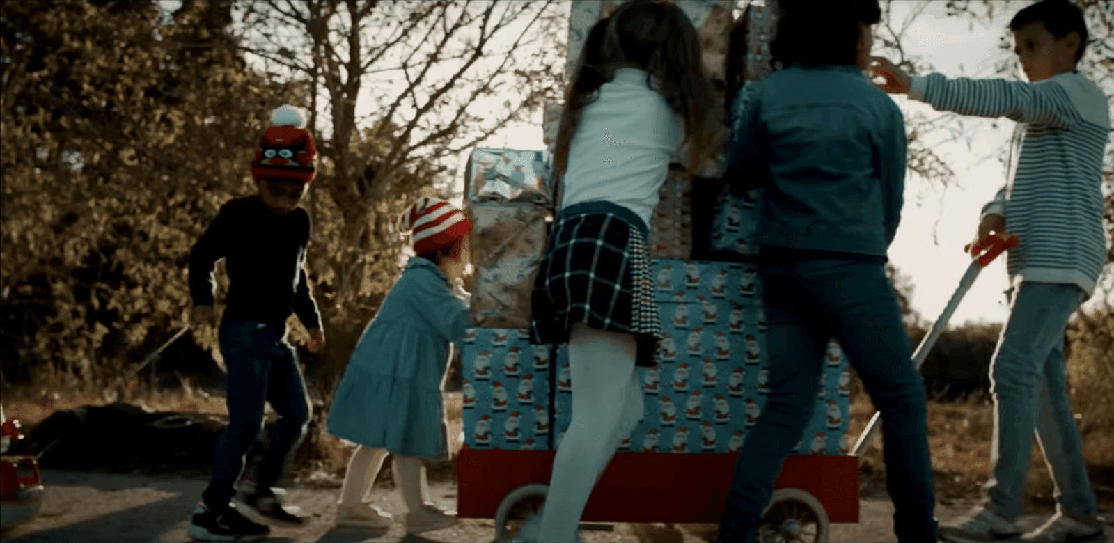 The kids pushing the cart with gifts forward