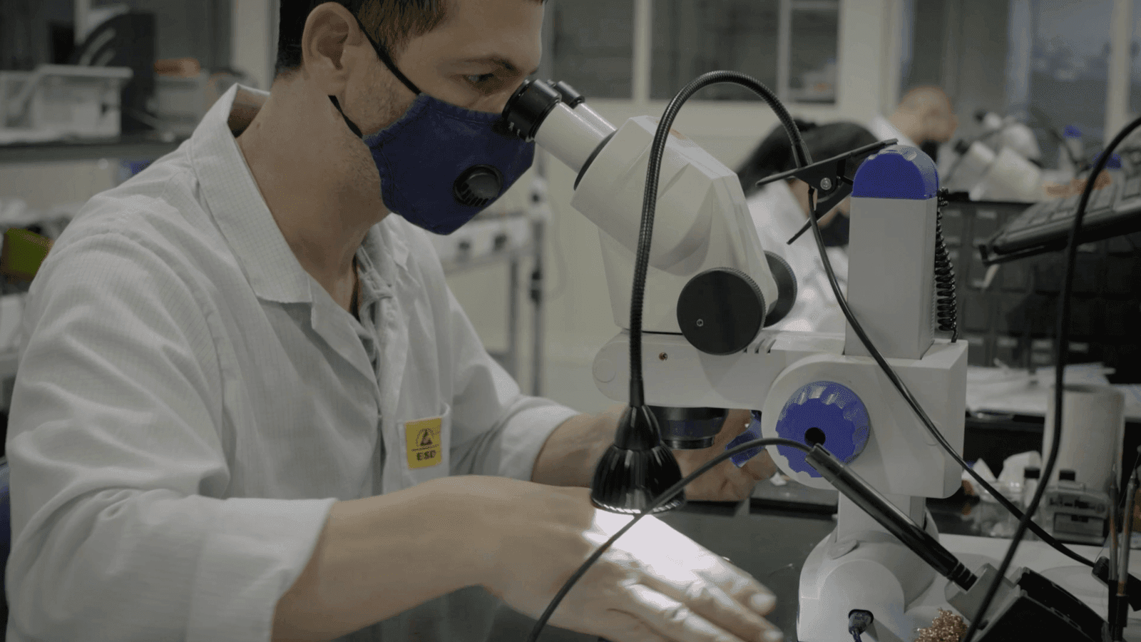 Fizoptika Personnel on a microscope in l-Intrapriża